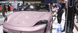 Besucher betrachten den elektrischen Porsche Taycan vom Automobilhersteller Porsche auf der Internationale Automesse.