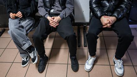 Drei junge Geflüchtete sitzen in einem Raum der Erstaufnahme auf dem Gelände der Zentralen Ausländerbehörde Brandenburgs (ZABH). 