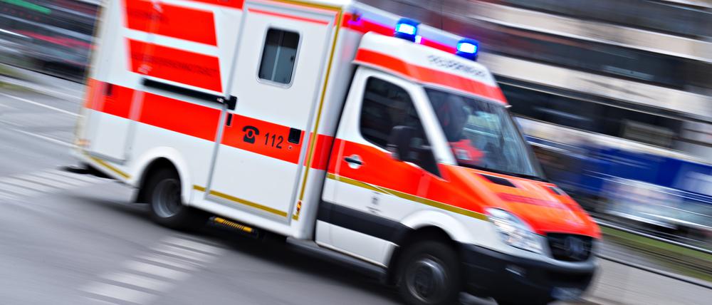 Ein Rettungswagen fährt mit Blaulicht (Aufnahme mit langer Belichtungszeit).