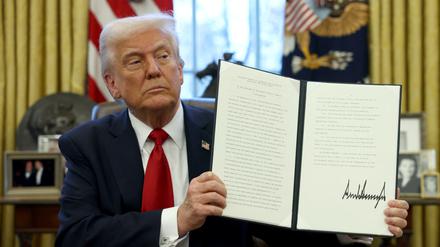 U.S. President Donald Trump shows a signed document in the Oval Office at the White House in Washington, D.C., U.S., March 26, 2025. REUTERS/Evelyn Hockstein