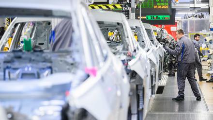 Mitarbeiter arbeiten im VW-Stammwerk an Neuwagen (Symbolbild).