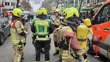 Feuerwehrleute stehen in der Wilmersdorfer Straße in Berlin-Charlottenburg.