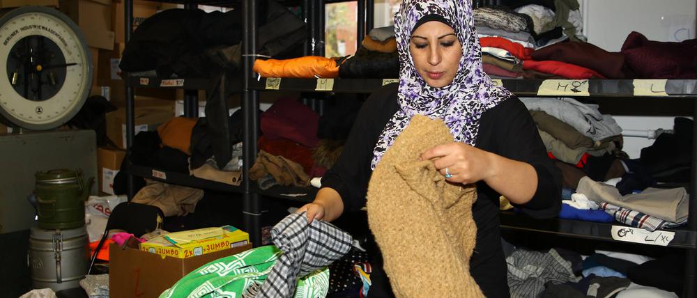 Berlin Mitarbeiter und freiwillige Helfer von „Moabit hilft“ übernehmen die Annahme und Verteilung von Kleidungsstücken.