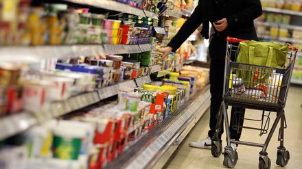 Ein Kunde bedient sich im Supermarkt-Regal.