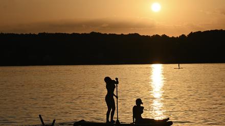 Stand-Up-Paddler genießen den Sommerabend auf dem Starnberger See.