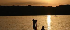 Stand-Up-Paddler genießen den Sommerabend auf dem Starnberger See.