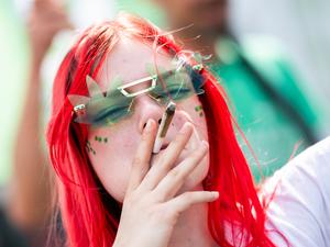 Eine Teilnehmerin raucht bei der 28. Hanfparade unter dem Motto „Legalisierung, aber richtig!“ einen Joint.