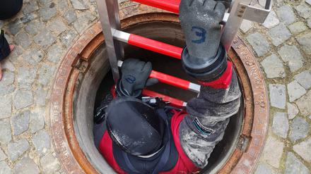 Ein Taucher der Berliner Feuerwehr klettert in den Adlon-Bunker. 