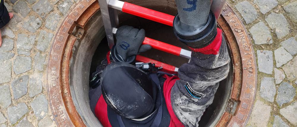 Ein Taucher der Berliner Feuerwehr klettert in den Adlon-Bunker. 