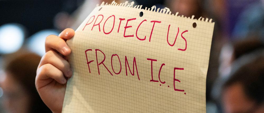 A demonstrator holds a sign calling for protection from U.S. Immigration and Customs Enforcement during a Board of Regents meeting at the University of Washington in Seattle, Washington, U.S., March 12, 2025.  REUTERS/David Ryder