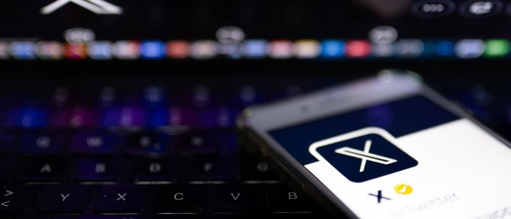 ARCHIV - 24.07.2023, Berlin: ILLUSTRATION - Auf dem offiziellen Profil der Plattform X auf dem Bildschirm eines Smartphones und auf dem Display eines Laptops ist der weiße Buchstabe X auf schwarzem Hintergrund zu sehen. (zu dpa: «Musk legt X mit seiner KI-Firma zusammen») Foto: Monika Skolimowska/dpa +++ dpa-Bildfunk +++