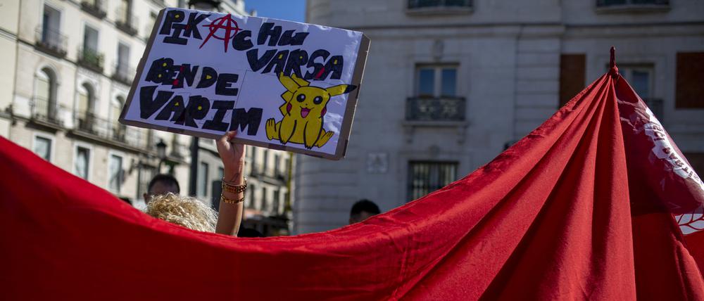 Ein Mitglied der türkischen Gemeinde in Madrid hält ein Plakat hinter einer riesigen türkischen Flagge, während einer Demonstration an der Puerta del Sol gegen die Verhaftung des Istanbuler Bürgermeisters Imamoglu. 