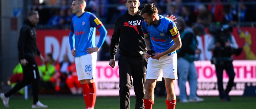 Kiels Trainer Marcel Rapp umarmt Marco Komenda nach der 0:3-Niederlage auf dem Rasen.