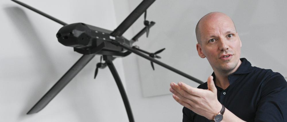 Gundbert Scherf, Mitgründer und Co-CEO von Helsing, steht an einem Modell einer HX-2-Drohne. 