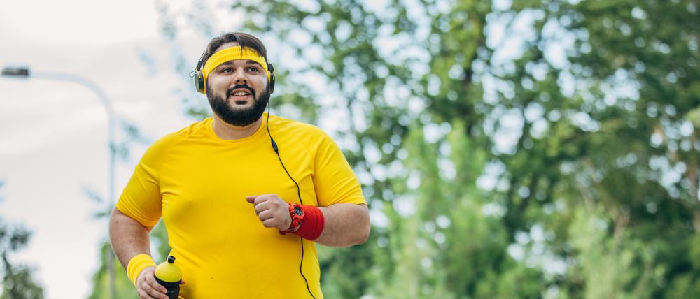Ein etwas fettleibiger junger Mann beim Joggen.