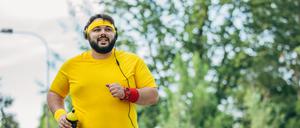 Ein etwas fettleibiger junger Mann beim Joggen.