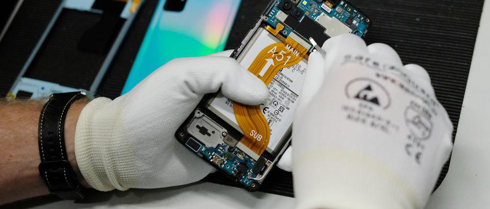 In einer Werkstatt wird ein altes Smartphone wiederaufbereitet.