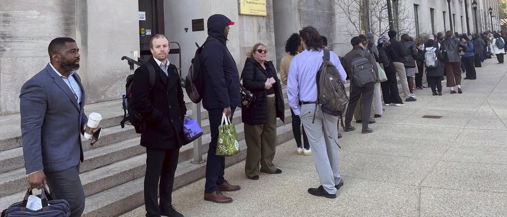 01.04.2025, USA, Washington: Angestellte stehen in einer Schlange vor dem Hauptgebäude der US-Gesundheitsbehörde.