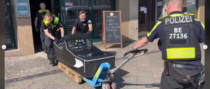 Polizisten verladen einen beschlagnahmten Spielautomaten