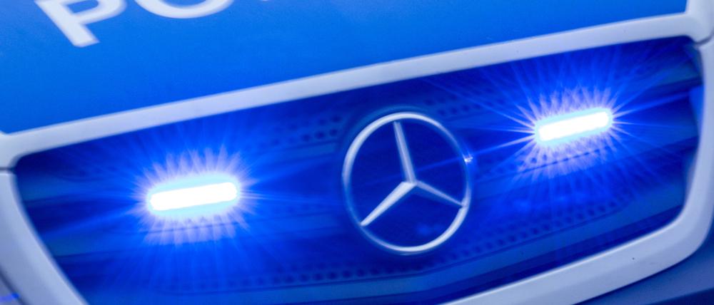 Ein Einsatzfahrzeug der Polizei fährt mit Blaulicht durch die Innenstadt.