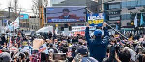 Südkoreanische Schaulustige beobachten in Seoul den Gerichtsprozess gegen den abgesetzten Präsidenten Yoon Suk Yeol.