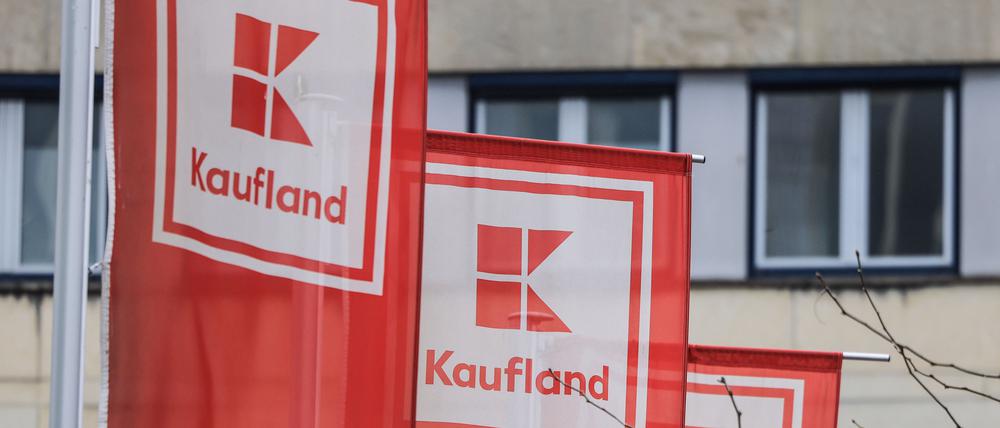 Flaggen von Kaufland hängen vor einer Filiale. 
