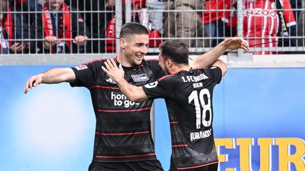 Andrej Ilic (links) freut sich zusammen mit Josip Juranovic über den Siegtreffer in Freiburg.