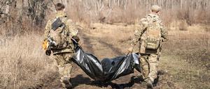 Freiwillige der Organisation Platsdarm tragen die Überreste eines russischen Soldaten. 