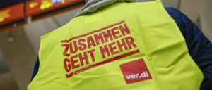 Ein Mann, der eine Warnweste mit der Aufschrift ·Zusammen geht mehr· trägt, steht im Terminal des Flughafens Köln Bonn. 