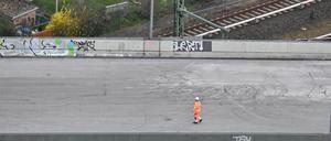 Ein Arbeiter steht auf der gesperrten Ringbahnbrücke der A100. Im Hintergrund sind Kleingärten zu sehen. Unter der aus Sicherheitsgründen gesperrten Autobahnbrücke ist seit vergangener Woche auch der S-Bahn-Verkehr auf unbestimmte Zeit unterbrochen. +++ dpa-Bildfunk +++