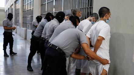 Gefängniswärter kontrollieren Insassen während eines Medienrundgangs im Gefängnis für terroristische Gefangene (Cecot) in El Salvador (Symbolbild).