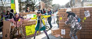 Teilnehmer versperren bei einer Demonstration gegen eine nächtliche Schließung des Görlitzer Parks und einen Zaun um den Park mit einer Mauer aus Pappe symbolisch den Weg in den Görlitzer Park.
