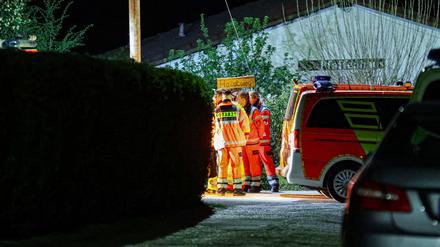 Helfer und ein Notarzt stehen in einer Kleingartenanlage in Wuppertal.