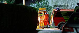 Helfer und ein Notarzt stehen in einer Kleingartenanlage in Wuppertal.