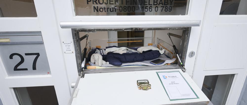 Eine Babyausstattung mit Schlafsack, Strampelanzug, Mütze und Kuscheltieren liegt in einem Wärmebett der Babyklappe im Kinderhaus Goethestraße in Hamburg-Altona. 