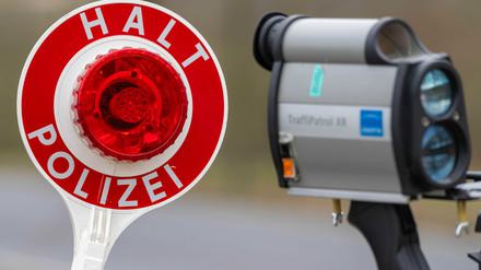 ARCHIV - 04.03.2025, Mecklenburg-Vorpommern, Bergen: Ein Polizist hält eine Kelle zum Anhalten von Autos und ein Geschwindigkeitsmessgerät anlässlich der Verkehrskontrollen der Kampagne "Fahren.Ankommen.LEBEN!". (zu dpa: «Blitzermarathon: Fakten und Kurioses zum Kampf gegen Raser») Foto: Stefan Sauer/dpa +++ dpa-Bildfunk +++