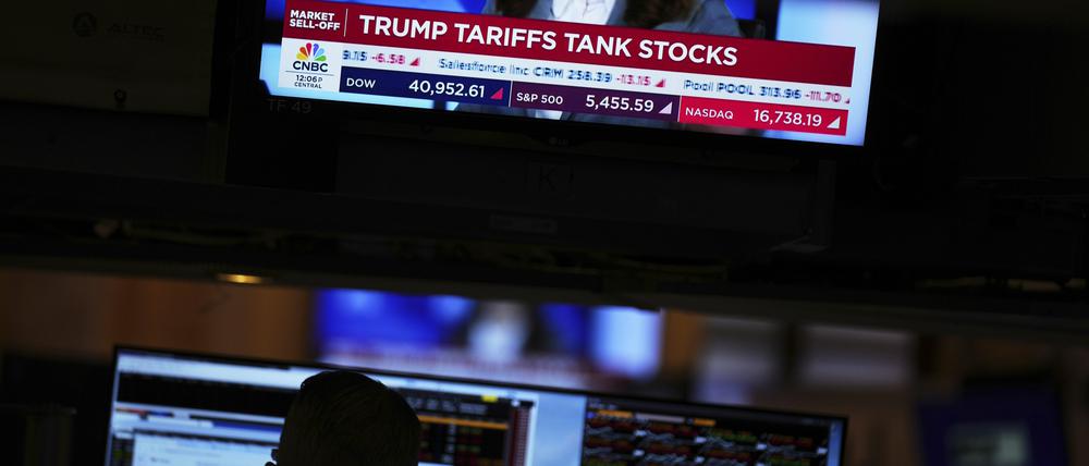ARCHIV - 03.04.2025, USA, New York: Auf einem Bildschirm werden Finanznachrichten angezeigt, während Händler auf dem Parkett der New Yorker Börse arbeiten. Mit Aktienverkäufen in großem Stil haben Investoren auf ebenso umfangreiche wie hohe Importzölle der Regierung Trump reagiert. (zu dpa: «Weißes Haus dementiert Gerüchte über 90-Tage-Pause für Zölle») Foto: Seth Wenig/AP/dpa +++ dpa-Bildfunk +++