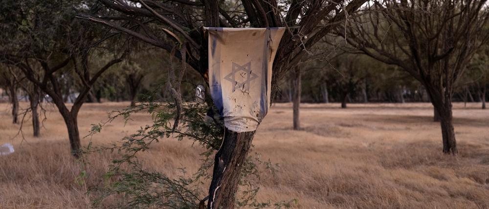 An einem Baum auf dem Gelände des Nova-Festivals hängt eine israelische Flagge.