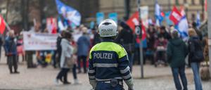 Polizisten beobachten eine Friedensdemo in Potsdam.
