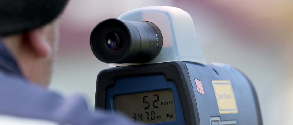Brandenburg, Fehrbellin: Ein Polizist misst mit einem Lasermessgerät die Geschwindigkeit von Verkehrsteilnehmern im Ortsteil Linum.