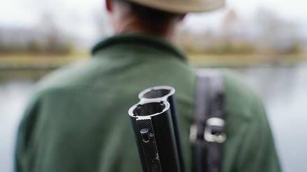 Ein Jäger steht mit seinem Gewehr in seinem Jagdrevier. 