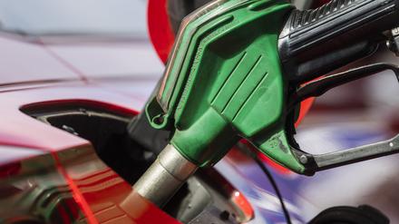 Ein Auto wird an einer Tankstelle betankt. 