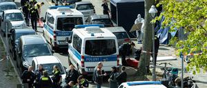 Polizisten und Beamte der Spurensicherung in weißen Schutzanzügen stehen am Fundort.