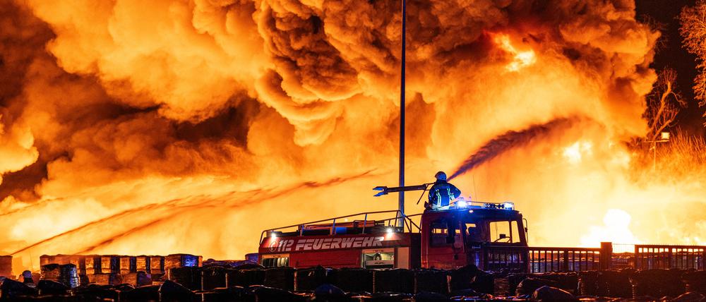 Einsatzkräfte der Feuerwehr löschen einen Brand auf dem Gelände einer kunststoffverarbeitenden Firma in einem Gewerbegebiet in Ahlen.