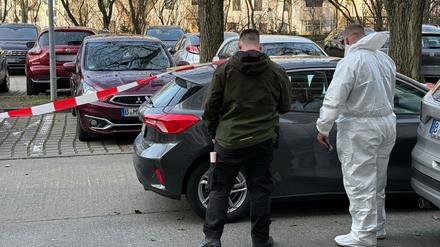Nach dem gewaltsamen Tod eines 88-Jährigen stehen zwei Beamte der Spurensicherung vor einem Auto, das mit Absperrband gesichert ist. (Archivbild)