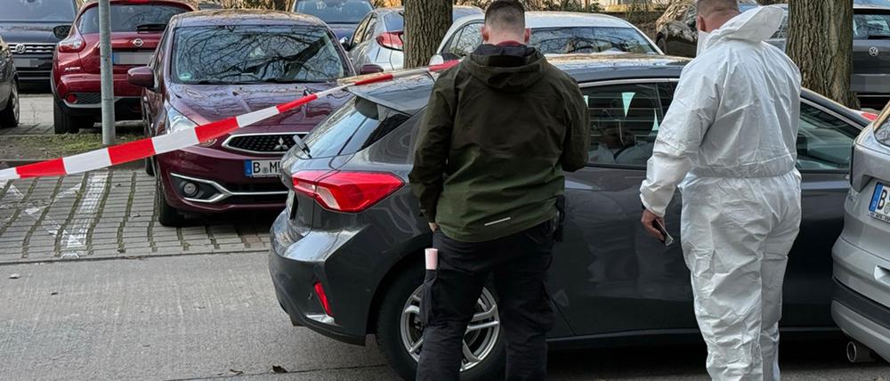 Nach dem gewaltsamen Tod eines 88-Jährigen stehen zwei Beamte der Spurensicherung vor einem Auto, das mit Absperrband gesichert ist. (Archivbild)