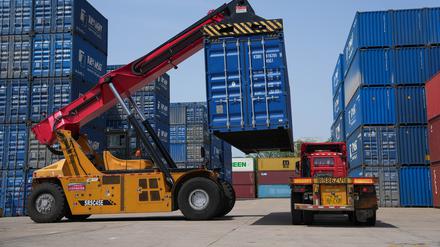 Ein Containerlader belädt Container in einem Logistikunternehmen im Bezirk Beilun der Stadt Ningbo in der ostchinesischen Provinz Zhejiang.