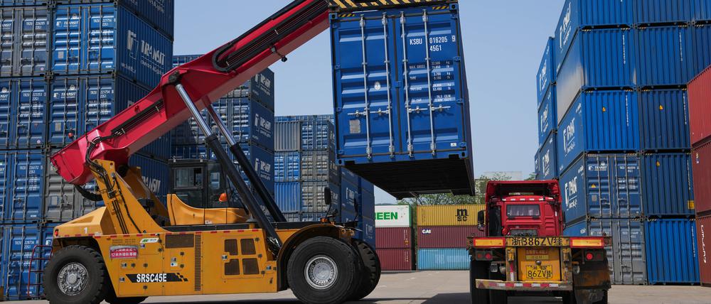 Ein Containerlader belädt Container in einem Logistikunternehmen im Bezirk Beilun der Stadt Ningbo in der ostchinesischen Provinz Zhejiang.