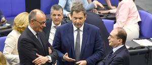 Friedrich Merz, Lars Klingbeil und Alexander Dobrindt beraten sich im  Bundestag. 