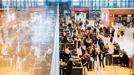 Passagiere stehen am Flughafen Berlin Brandenburg.